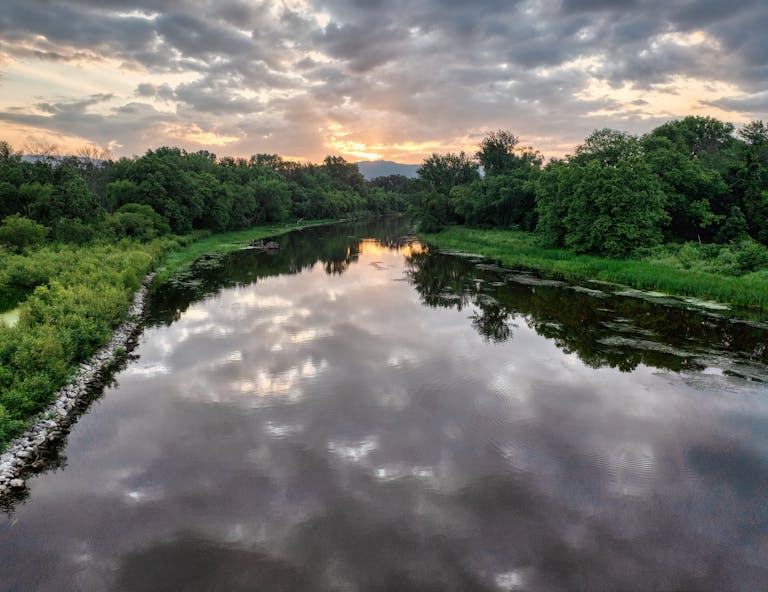 Beautiful view of a calm river reflecting a cloudy sunset sky in Minnesota.