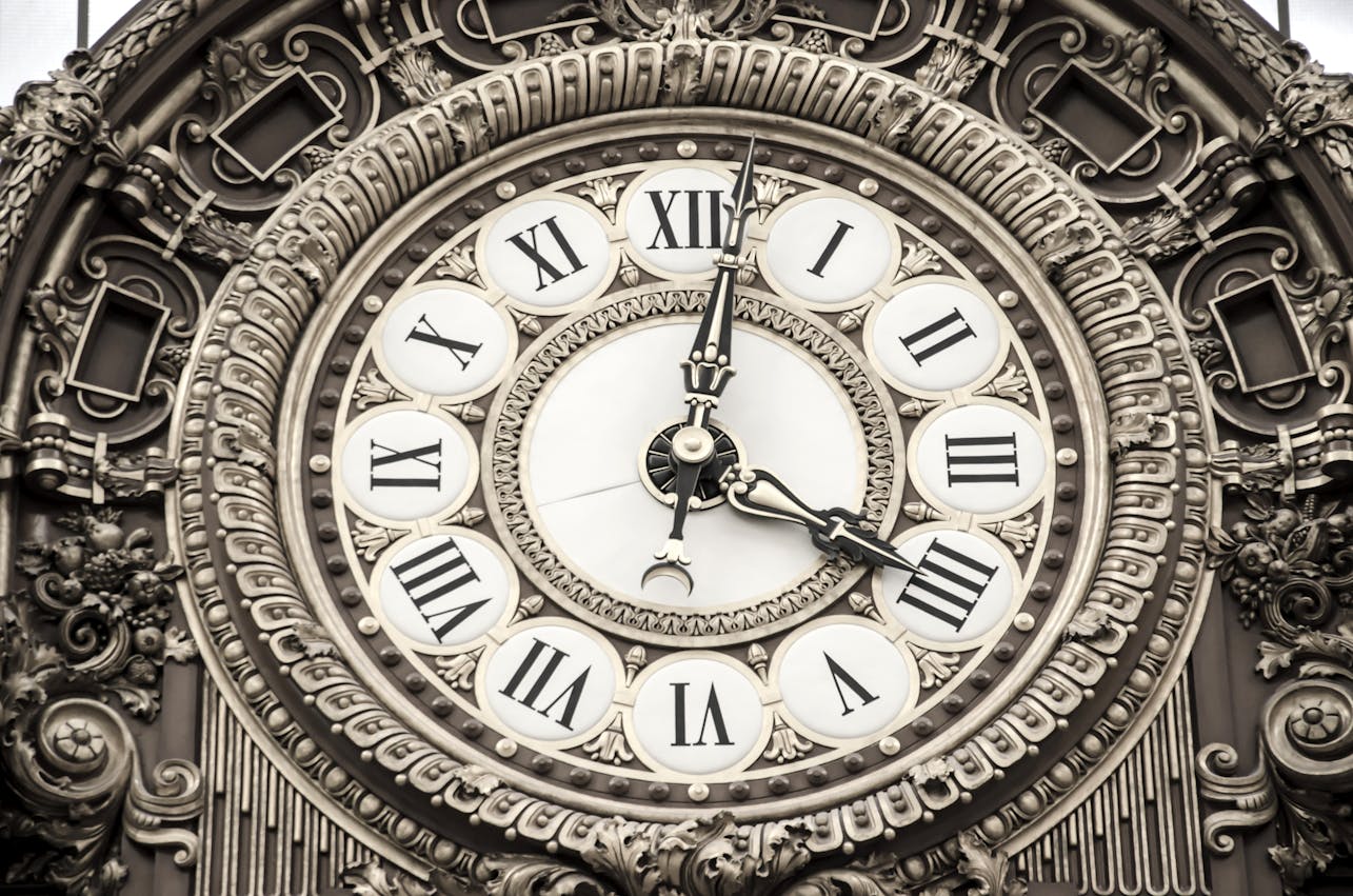 Close-up of an ornate clock face featuring Roman numerals and intricate details.
